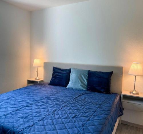 a bedroom with a blue bed with two lamps at Veermaster in Breege