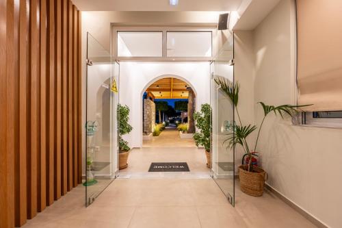 a hallway with glass doors and potted plants at Cirillo Family Hotel-Christinas Studios in Mastichari