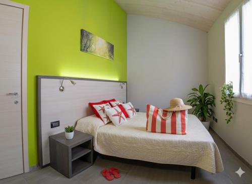 a bedroom with green walls and a bed with red pillows at Il Sole Di Bruno in Imperia