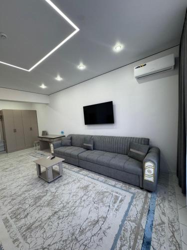 a living room with a couch and a flat screen tv at Отель Жанатас in Zhangatas