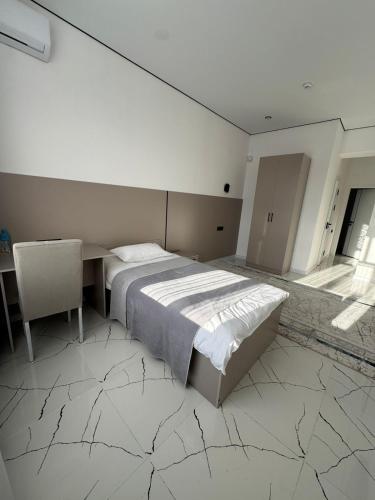 a bedroom with a bed and a desk and a table at Отель Жанатас in Zhangatas