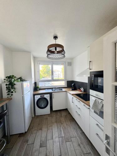 a kitchen with a refrigerator and a washing machine at Chambre Evasion Tout confort Saint Marceau in Orléans