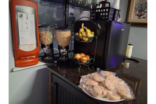 een aanrecht met een blender en een fruitschaal bij Capital O Aurora Inn Monett US 60 in Aurora