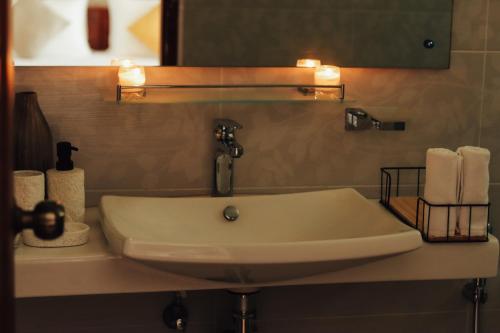 ein Waschbecken im Bad mit einem Spiegel und Handtüchern in der Unterkunft Villa 1818 - Wellawaya in Wellawaya