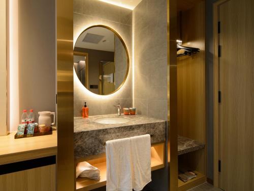 ein Badezimmer mit Waschbecken und Spiegel in der Unterkunft Orange Hotel Shanghai New International Expo Centre in Shanghai