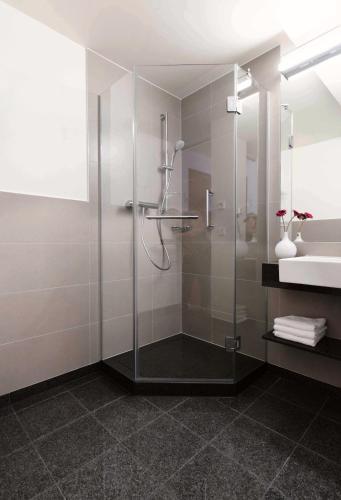 a bathroom with a glass shower and a sink at MAVO Hospitality Esslingen Berliner Straße in Esslingen