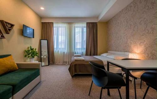 a hotel room with a bed and a table at New Gudauri Rooms in Gudauri