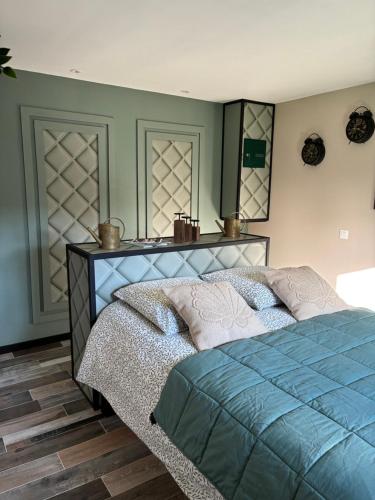 una camera da letto con un letto con un piumone blu di Le Hangar - Studio esprit industriel a Pont-Rémy