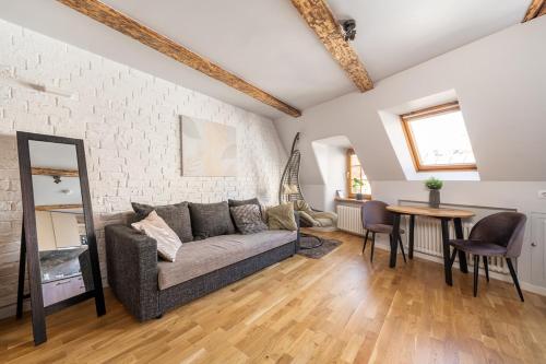 a living room with a couch and a table at Old Town Gem - Rooftop Studio - By Innorental in Rīga