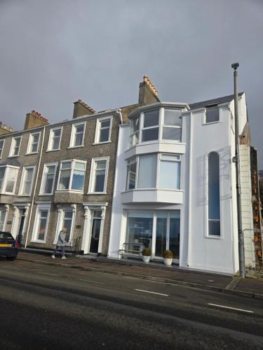 ein großes weißes Gebäude am Straßenrand in der Unterkunft Seaside in Portrush