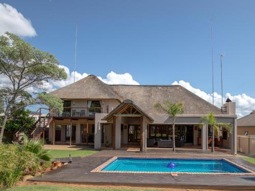 a house with a swimming pool in front of it at Weavers Nest Guesthouse in Modimolle