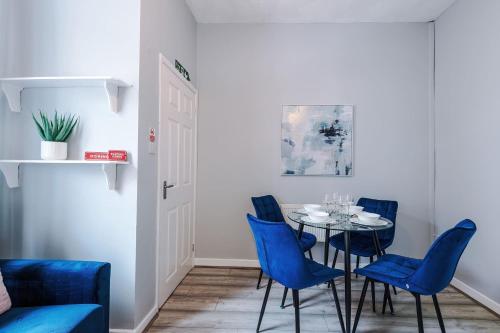 une salle à manger avec une table et des chaises bleues dans l'établissement St Helens Central, 2 Bed , Long Stay OFFERS, Contractors, Relocations, Families, Sleeps 4, à St Helens