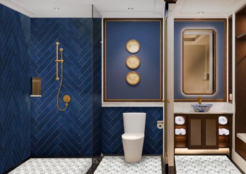 ein Bad mit einem WC und einer blauen Wand in der Unterkunft Ashley NewAir Menteng with Air Purifier in Jakarta