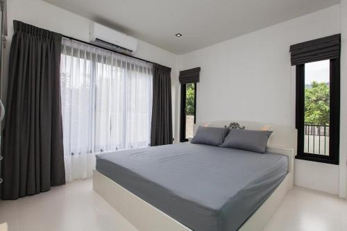 a bedroom with a bed and a large window at Ali Cozy Houses in Ban Thalat Choeng Thale