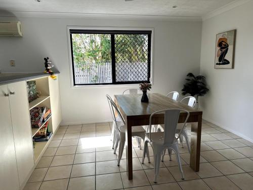 a dining room with a table and chairs and a window at The Kirwan Nestle Retreat in Ross River