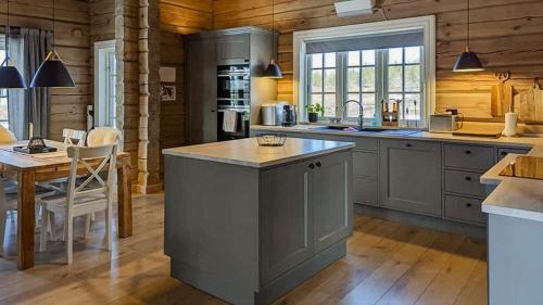 una cocina con una isla en el medio de una habitación en Tømmerhytte Ved Historiske Senhovd, en Veggli