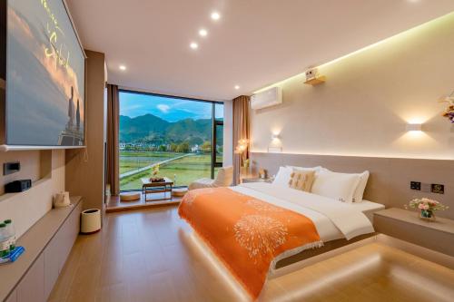 a bedroom with a large bed and a large window at Yu Ni Meisu-wang xian gu Branch in Qiaotou