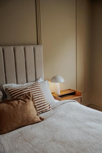 a bedroom with a large white bed and a lamp at Hotel Vest Mar in Ólafsvík