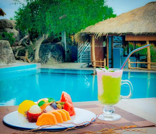 een bord eten en drinken naast een zwembad bij Oruwa Boutique Villa in Pottuvil