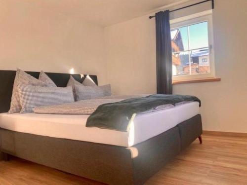 een groot bed in een slaapkamer met een raam bij Appartementhaus Bad Salve in Hopfgarten im Brixental