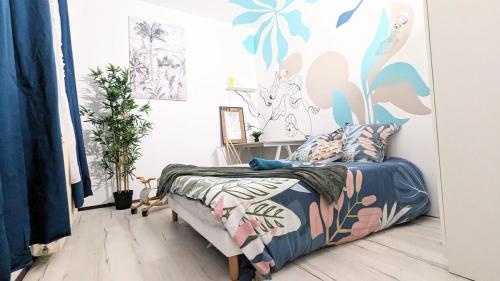 Schlafzimmer mit einem Bett mit Wandbild in der Unterkunft Cosy Jolie T3 - Centre - Parking souterrain in Mantes-la-Jolie
