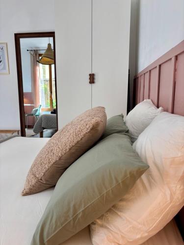a bed with four pillows on top of it at L'Escapade Mussipontaine in Pont-à-Mousson