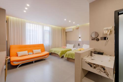 a hotel room with a bed and a chair and a sink at Yu Ni Meisu-wang xian gu Branch in Qiaotou