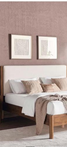 a bedroom with a white bed with two pictures on the wall at The mirage dome in Bidiyah