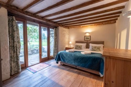 a bedroom with a bed and a large window at Middlewick Holiday Cottages in Glastonbury