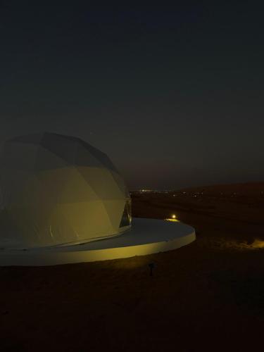a boat sitting on the beach at night at The mirage dome in Bidiyah