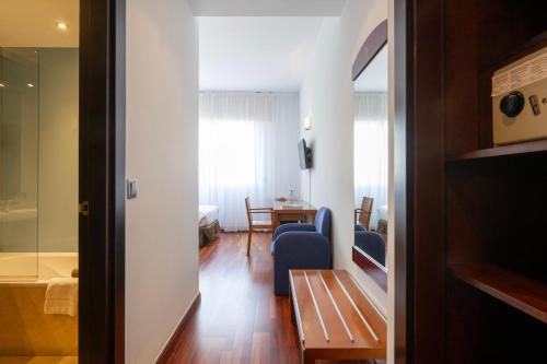 a living room with a blue couch and a table at Hotel Maroa Vigo in Vigo