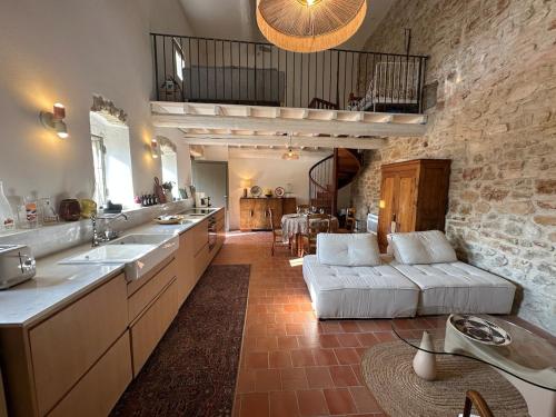 Una gran cocina con un sofá y una sala de estar. en Maison pure style provençale-jardin clôturé-4 pers, en Collorgues