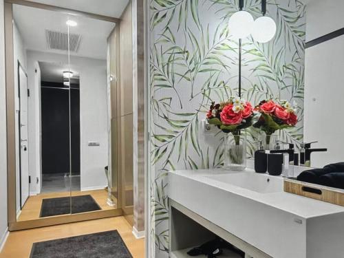 un bagno con lavandino e fiori su un muro di Skyline views a Bucarest