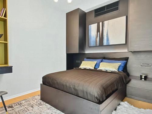 una camera da letto con un letto con cuscini blu di Skyline views a Bucarest