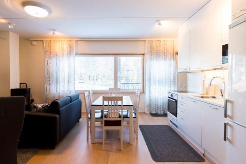 eine Küche und ein Wohnzimmer mit einem Tisch und einer Couch in der Unterkunft Levin Stara C 14 Visit Levi in Levi