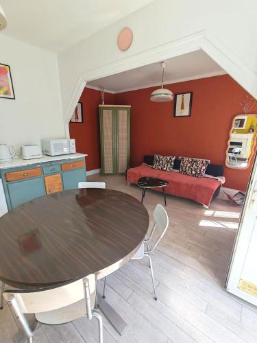charming townhouse في ميشيرس سور جيغوند: غرفة معيشة بها طاولة وأريكة