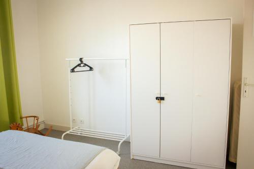 ein Schlafzimmer mit einem großen weißen Schrank neben einem Bett in der Unterkunft L Albéra - Elégance et douceur in Albertville
