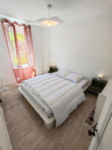 charming townhouse في ميشيرس سور جيغوند: غرفة نوم بها سرير كبير في غرفة بها نافذة