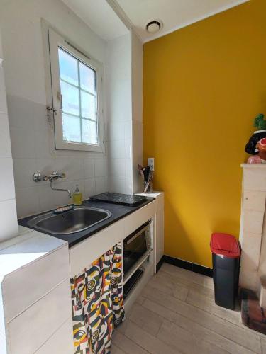 charming townhouse في ميشيرس سور جيغوند: مطبخ صغير مع حوض ونافذة