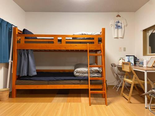 two bunk beds in a room with a desk at Puka Puka 1組限定 in Oshima