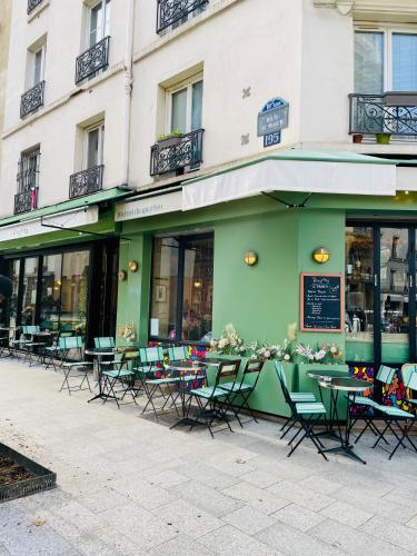 eine Gruppe von Tischen und Stühlen außerhalb eines Gebäudes in der Unterkunft Jin's cosy apartment at Paris 10ème in Paris