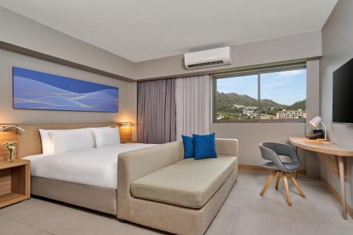 a hotel room with a bed and a couch at Mercure Phuket Patong Journeyhub in Patong Beach