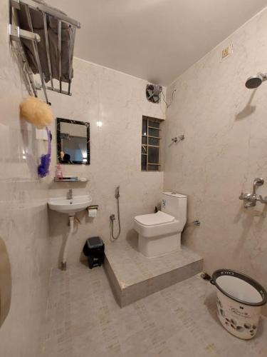 a bathroom with a toilet and a sink and a toilet istg at The Mishing Room in Guwahati