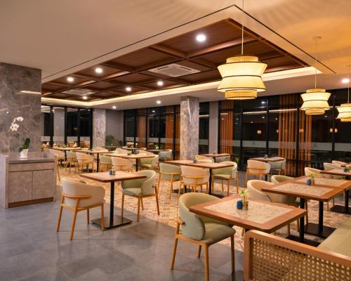 a restaurant with tables and chairs in a room at Laska Hotel & Resort Ciater in Ciater