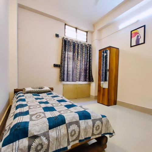 a bedroom with a bed and a window at The Mishing Room in Guwahati