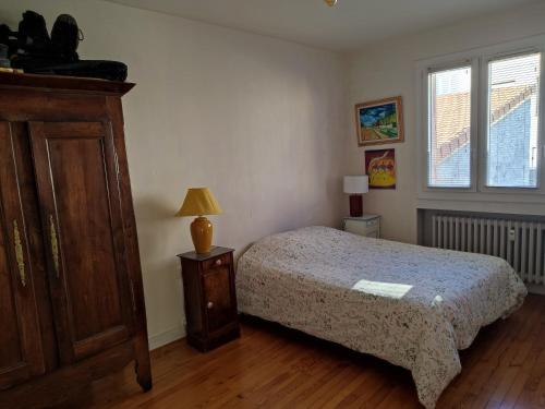a bedroom with a bed and a dresser and a window at Appartement plein centre in Saint-Étienne