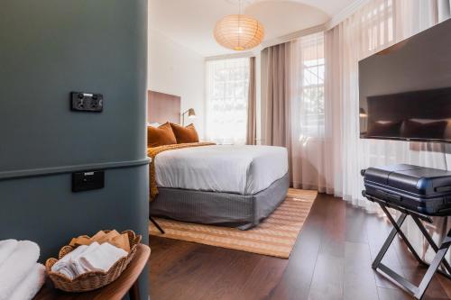 a bedroom with a bed and a television in it at Kurrajong Hotel Sydney in Sydney
