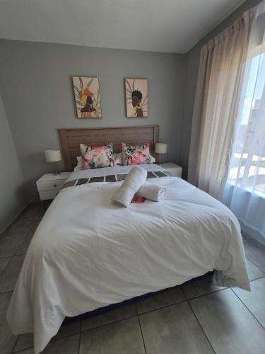 a bedroom with a large white bed with two pillows at Mlangeni's Rest in Centurion