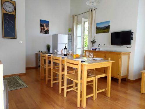 een keuken met een grote houten tafel en stoelen bij L'ourmeou in Coursegoules