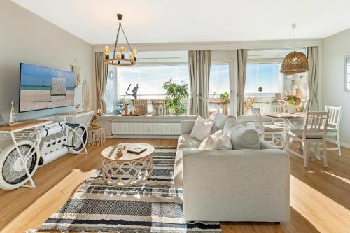 uma sala de estar com um sofá e uma mesa em Panoramic Loft mit Meerblick em Sierksdorf